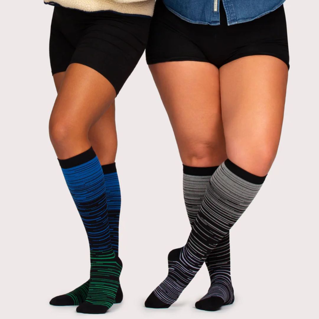 Two-tone 20-30 mmHg compression socks worn up the calf, in black, pink, blue and light blue