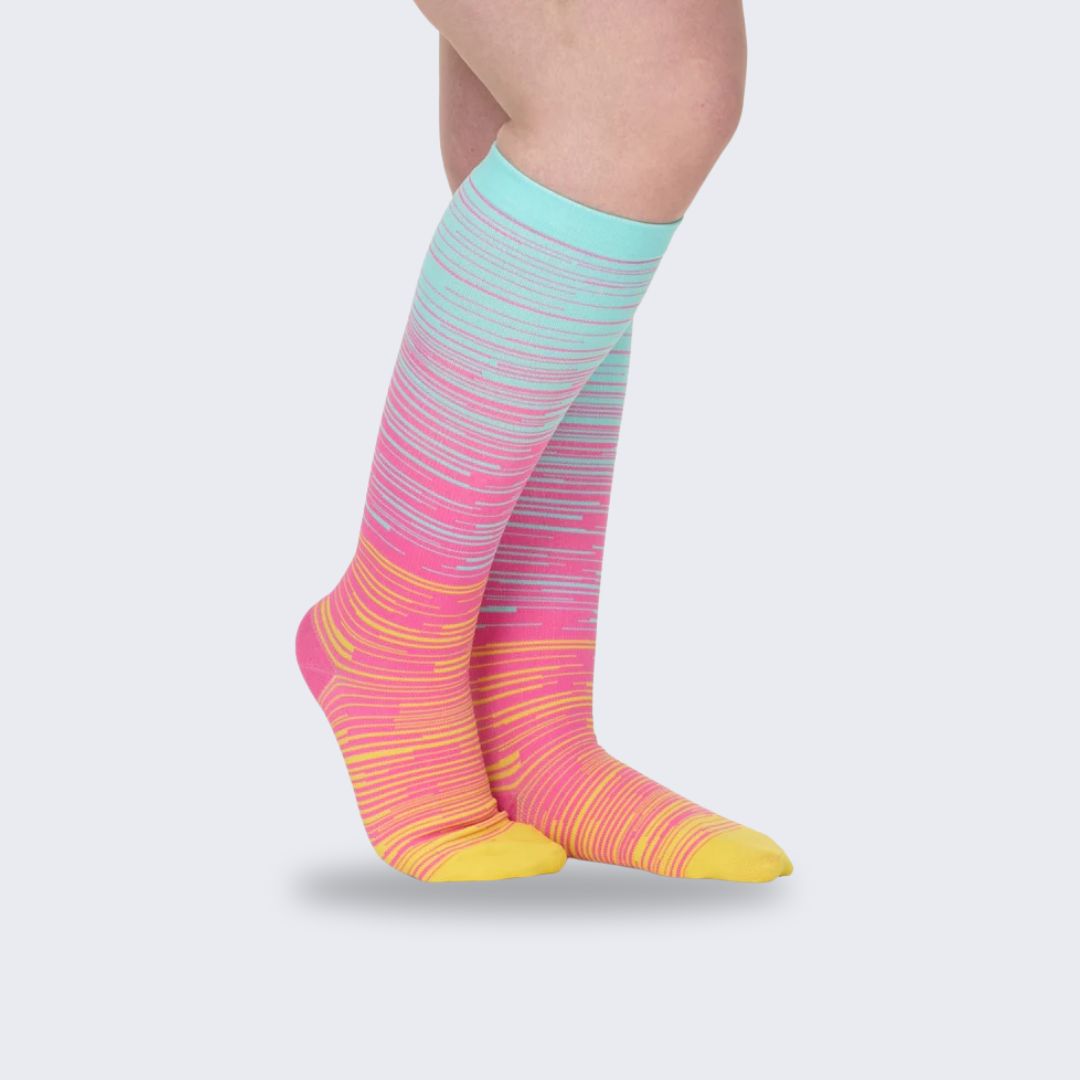 Two-tone 20-30 mmHg compression socks worn up the calf, in black, pink, blue and light blue