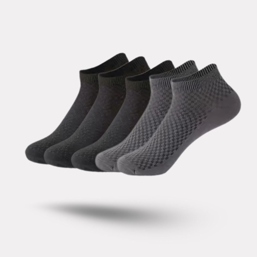 Five pairs of soft bamboo fiber socks in black and gray, worn up to mid-calf