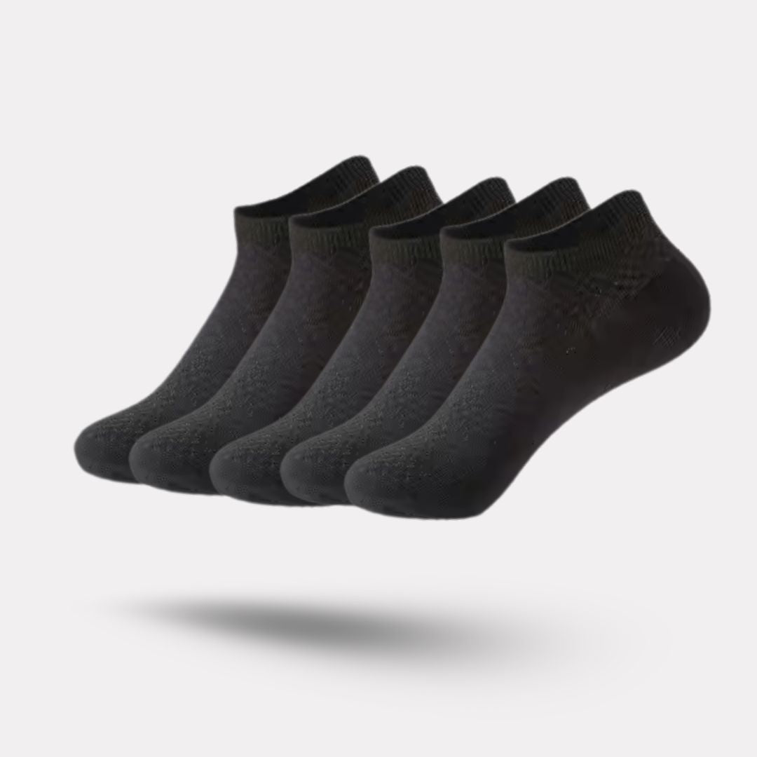 Five pairs of soft bamboo fiber socks in black and gray, worn up to mid-calf