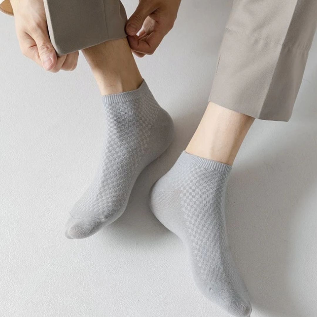 Five pairs of soft bamboo fiber socks in black and gray, worn up to mid-calf