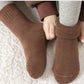 Five pairs of thick knit winter socks for kids, worn up to mid-calf