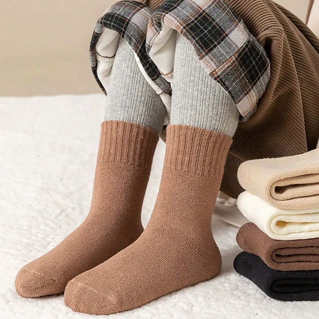 Five pairs of thick knit winter socks for kids, worn up to mid-calf