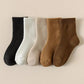 Five pairs of thick knit winter socks for kids, worn up to mid-calf