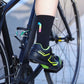 Black cycling socks with reflective stripes, worn high on the calf