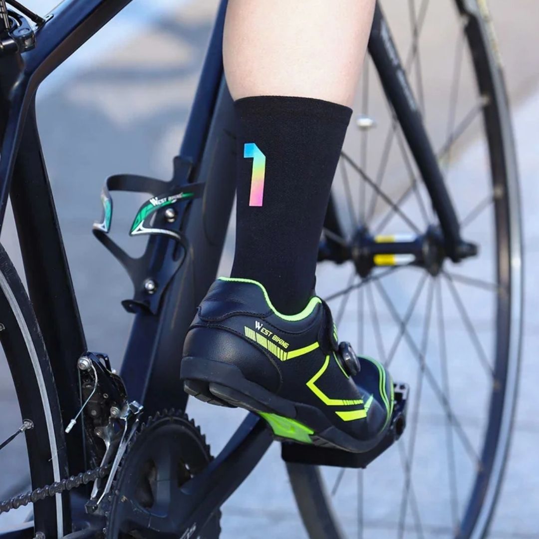 Black cycling socks with reflective stripes, worn high on the calf