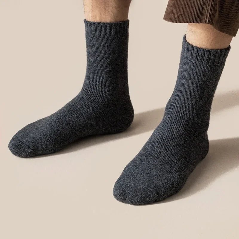 Pair of gray merino wool socks knitted for warmth and reaching mid calf