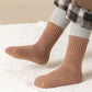 Five pairs of thick knit winter socks for kids, worn up to mid-calf