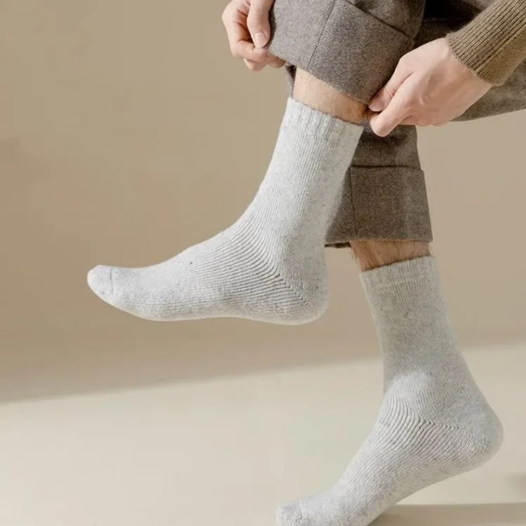 Thick merino wool winter socks in gray, black, khaki and brown, pulled up over the calf