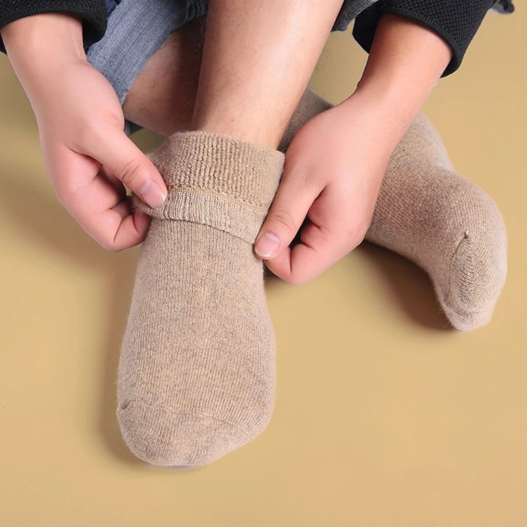 Thick merino wool winter socks in gray, black, khaki and brown, pulled up over the calf