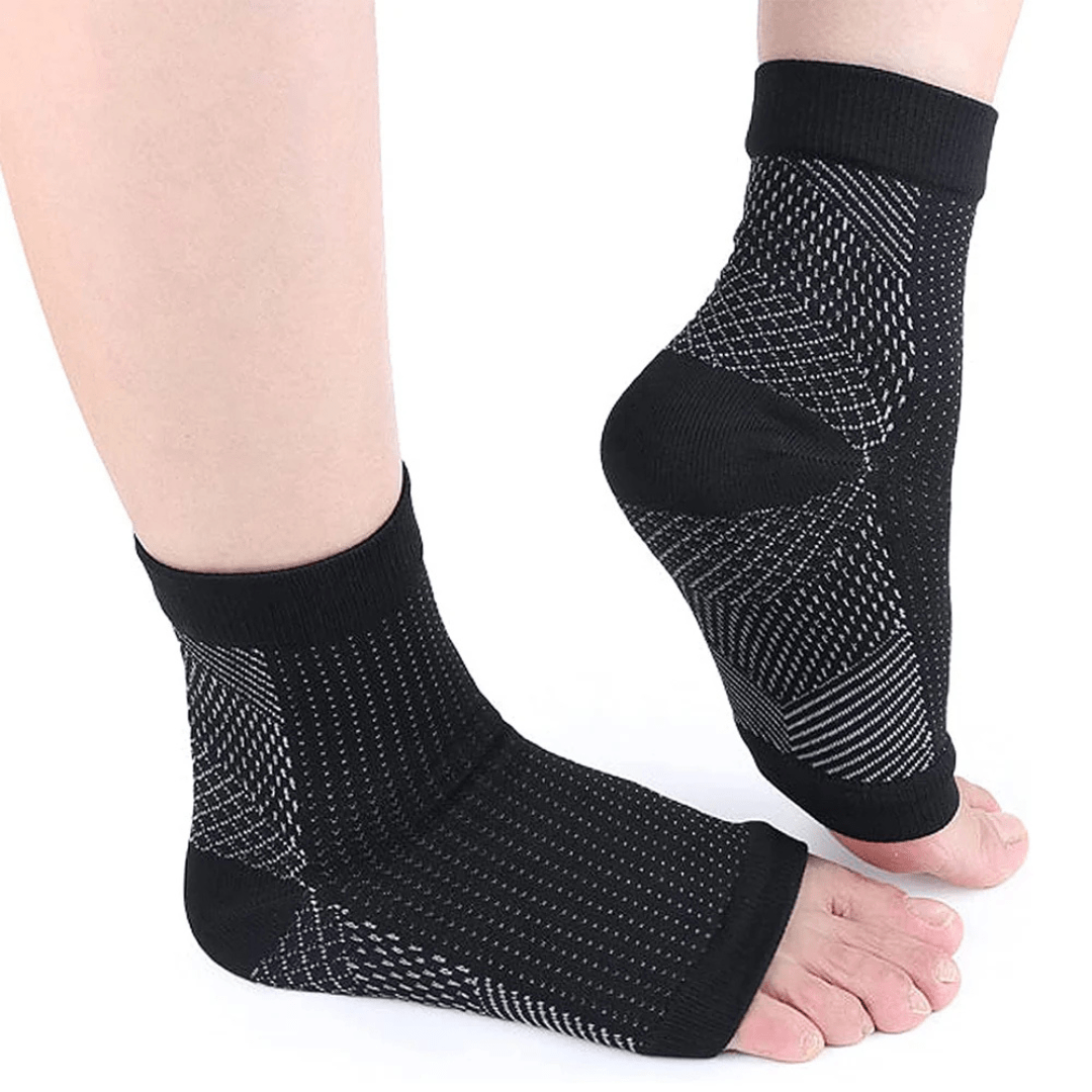 White and black anti-fatigue compression socks with flat seams, worn up the calf