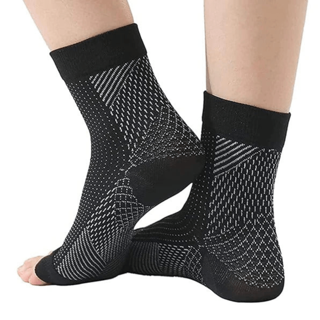White and black anti-fatigue compression socks with flat seams, worn up the calf