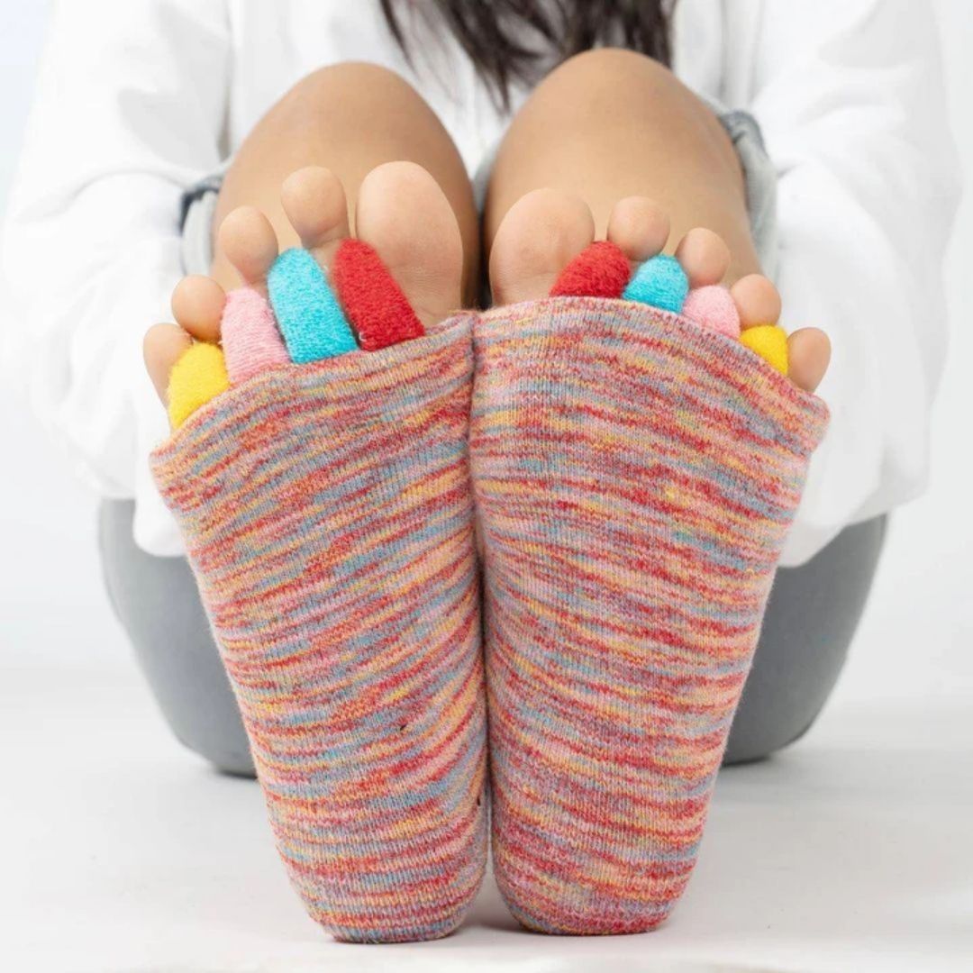 Bunion correction socks in black, gray, green and blue, worn over the forefoot and big toe