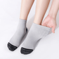 Gray compression socks with a firm band under the arch for plantar pain
