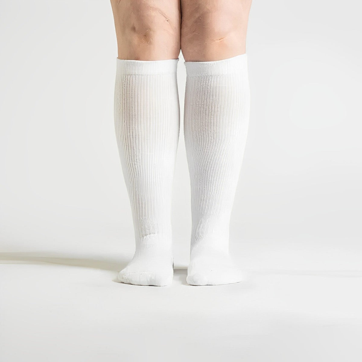 White seamless compression socks that stretch up the calf with no ridge at the toe