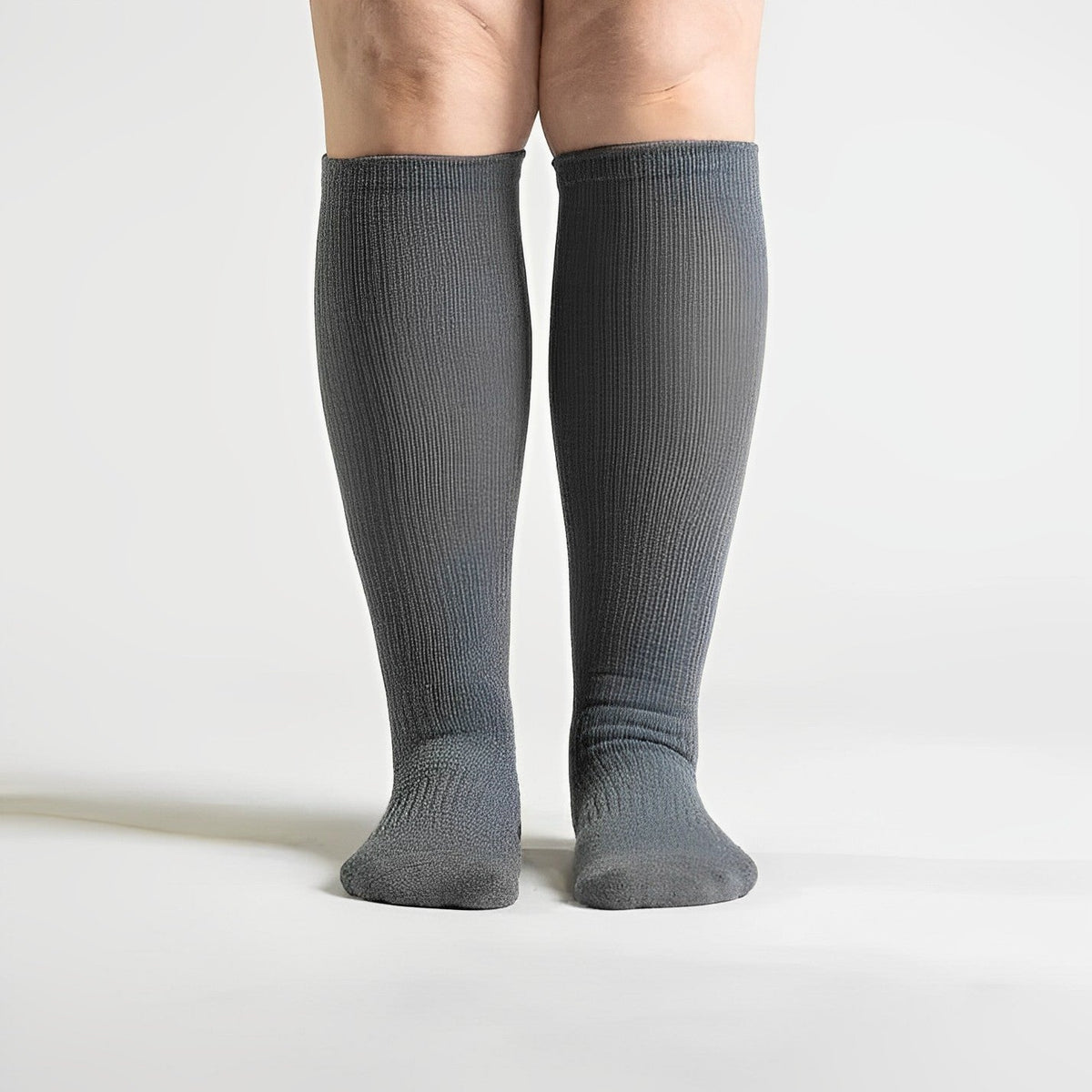 Gray seamless compression socks that stretch over the calf with no ridge at the toe