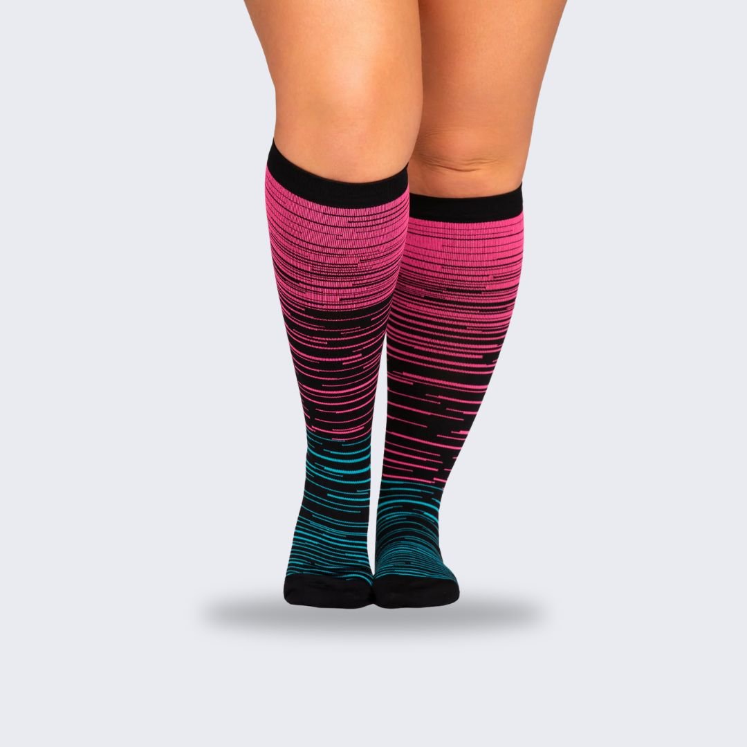 Two-tone 20-30 mmHg compression socks worn up the calf, in black, pink, blue and light blue