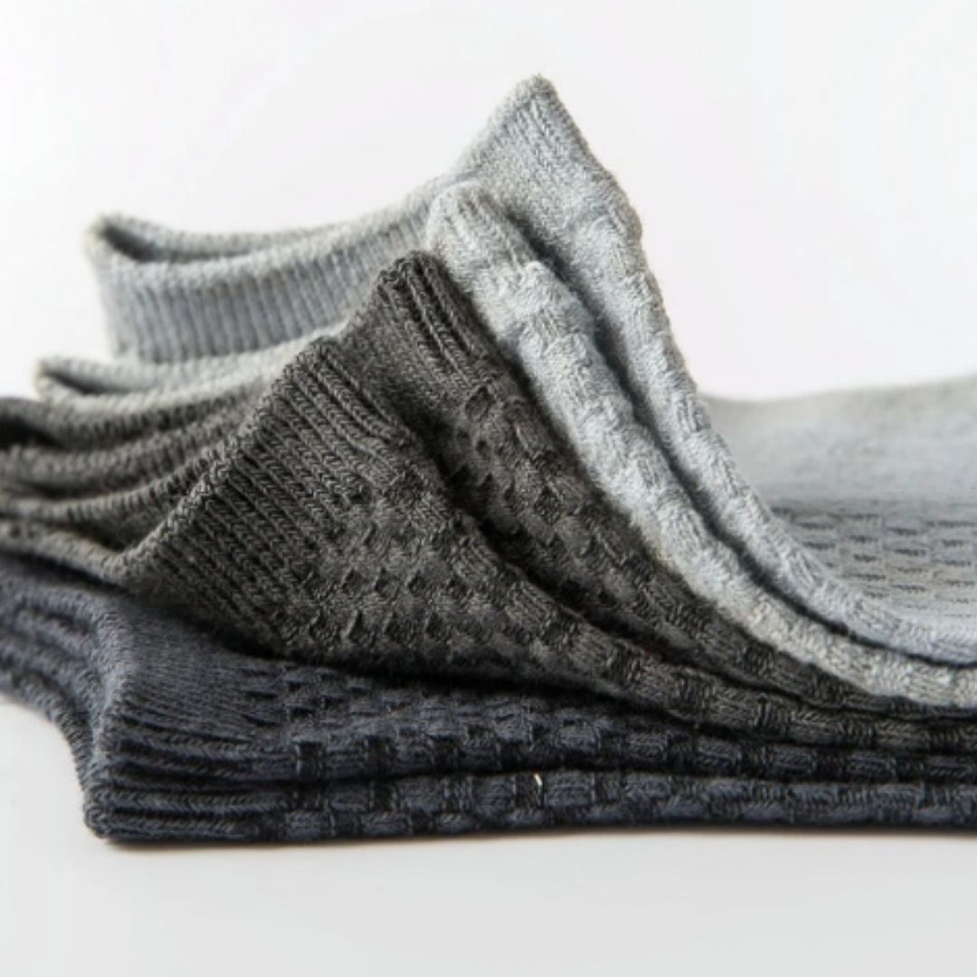 Five pairs of soft bamboo fiber socks in black and gray, worn up to mid-calf