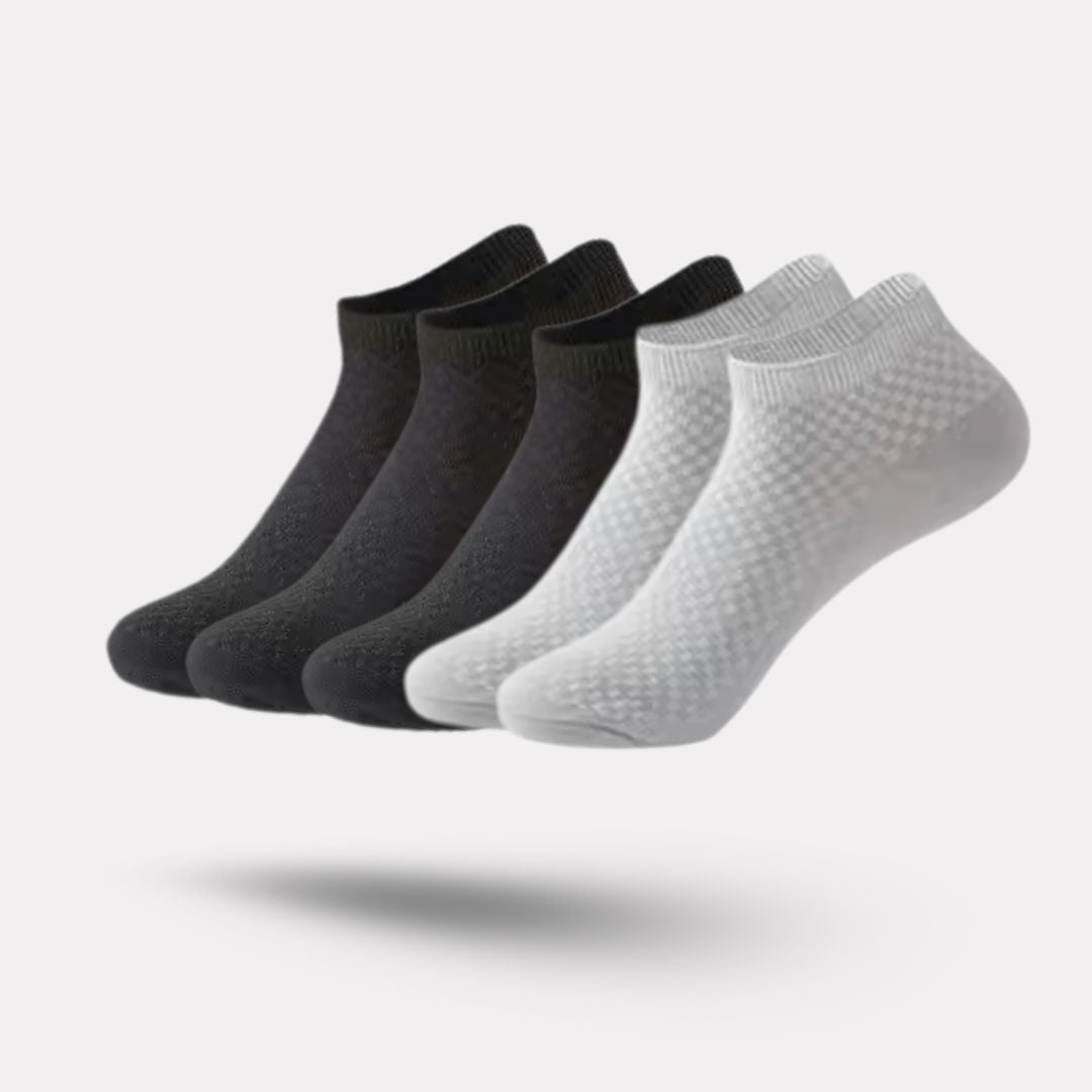 Five pairs of soft bamboo fiber socks in black and gray, worn up to mid-calf