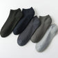 Five pairs of soft bamboo fiber socks in black and gray, worn up to mid-calf