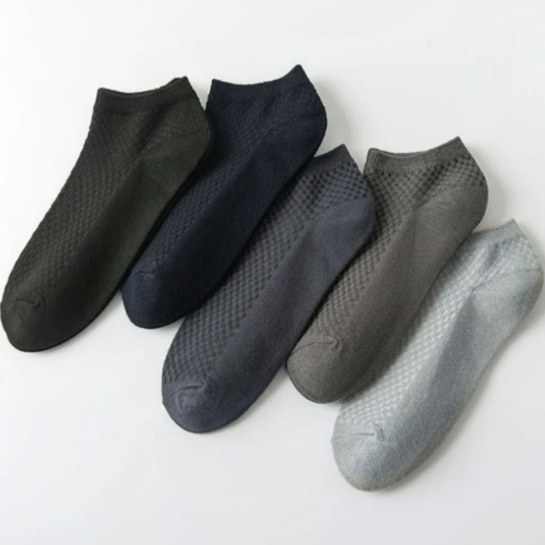 Five pairs of soft bamboo fiber socks in black and gray, worn up to mid-calf
