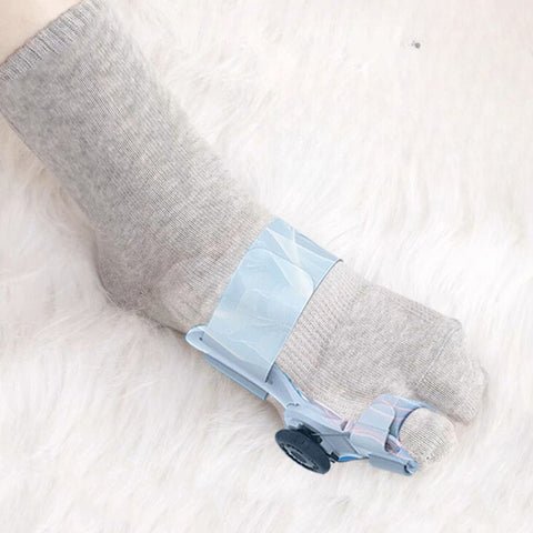 Gray, black and white socks shaped to fit around a bunion corrector on the big toe