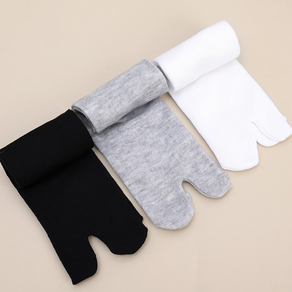 Gray, black and white socks shaped to fit around a bunion corrector on the big toe