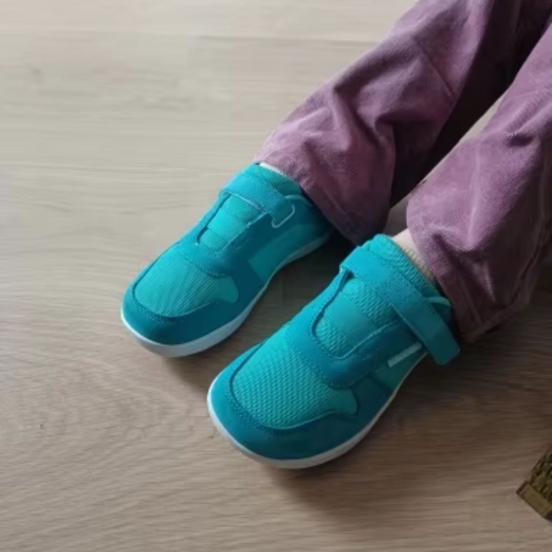 Blue barefoot shoes for kids with a thin flexible sole and a roomy toe box