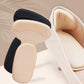 Clear anti-friction pads in black and beige, stuck inside the back of a high heel