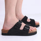 Cream sandals with two buckle straps and a contoured cork footbed
