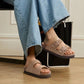 Cream sandals with two buckle straps and a contoured cork footbed