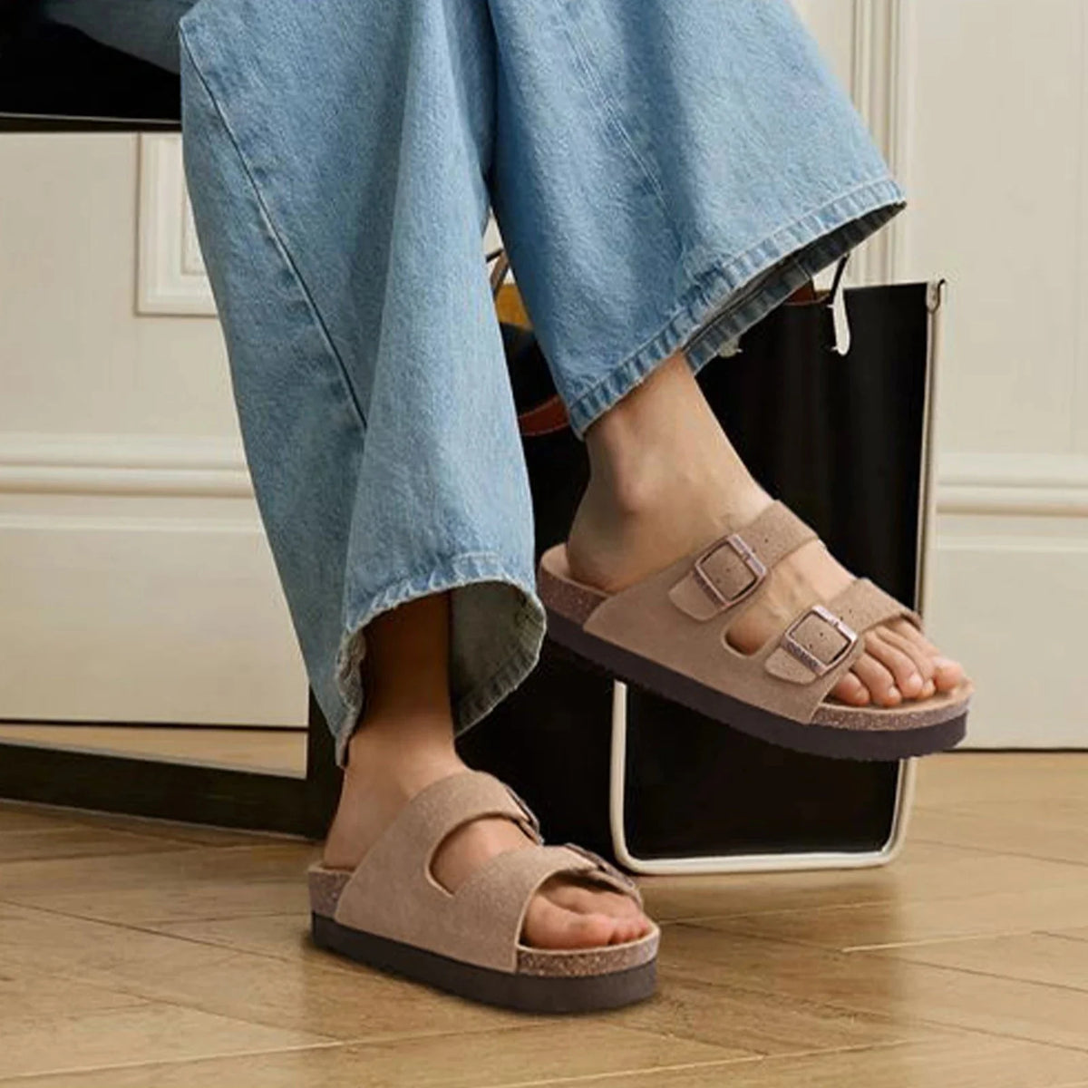 Cream sandals with two buckle straps and a contoured cork footbed