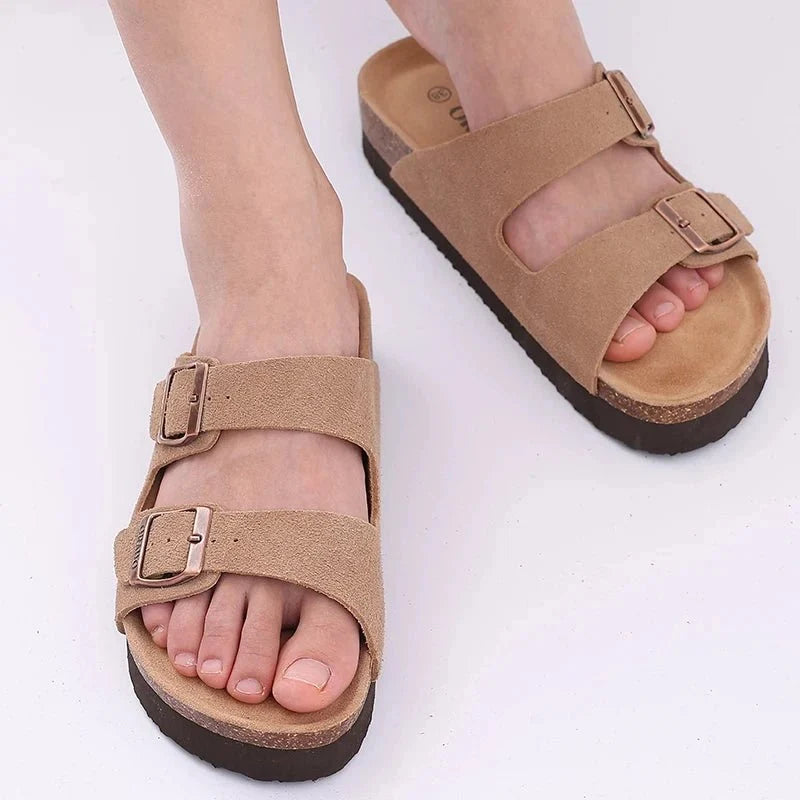 Cream sandals with two buckle straps and a contoured cork footbed