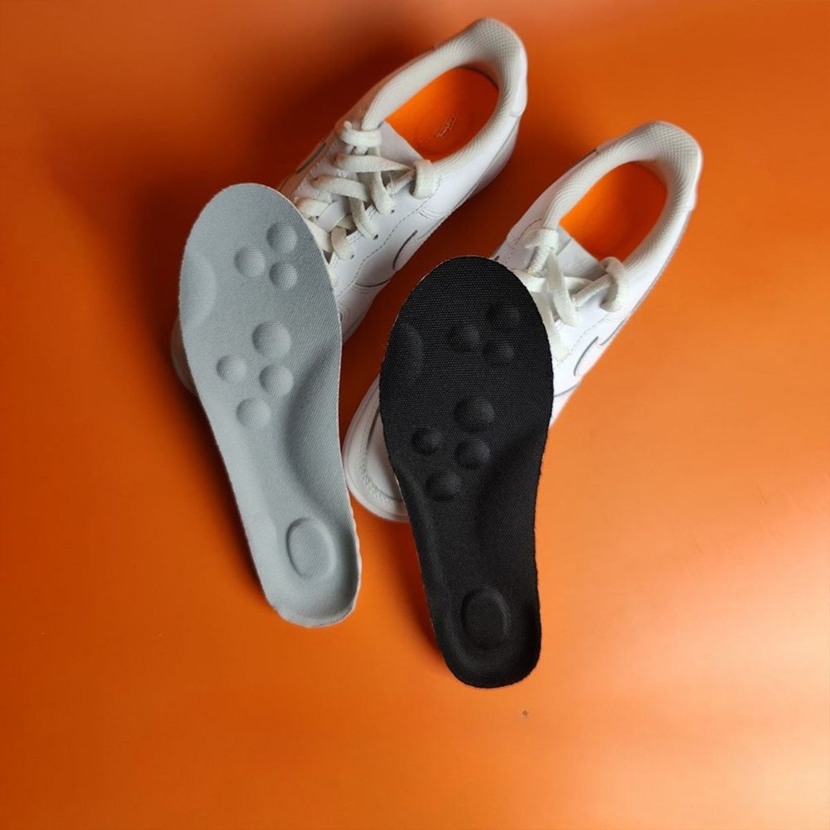 Pair of memory foam orthopedic insoles with a raised arch, worn inside the shoe