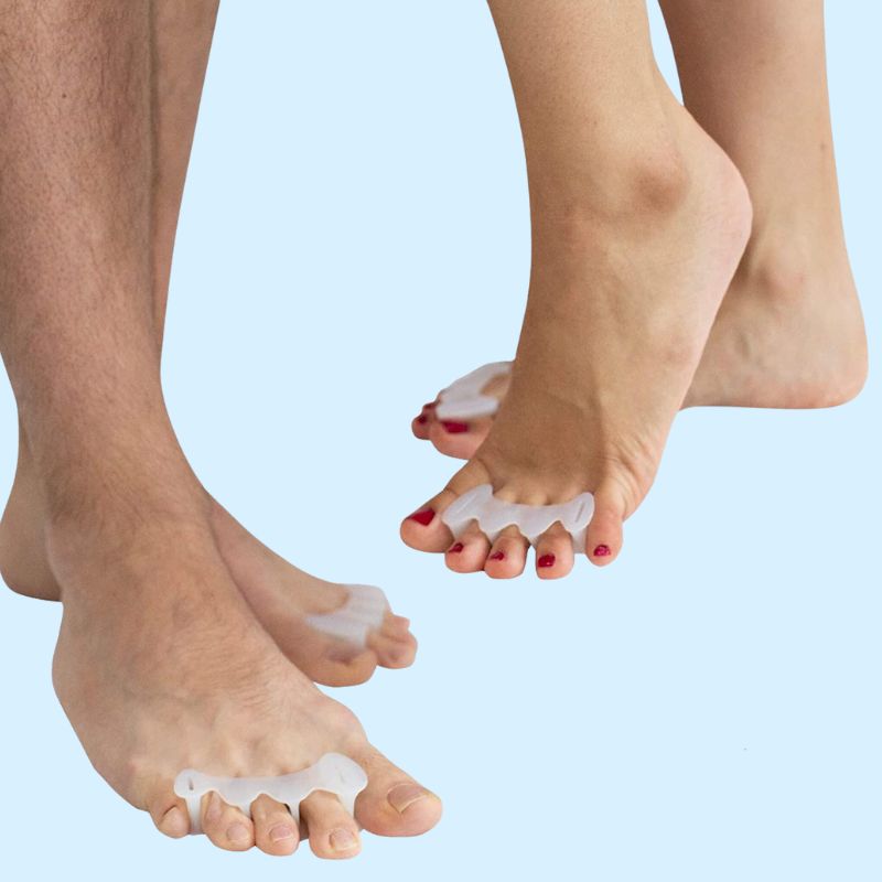 Soft silicone toe separators slotted between the toes to spread them apart