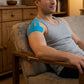 Blue, khaki and black elastic support strips applied across the shoulder for compression